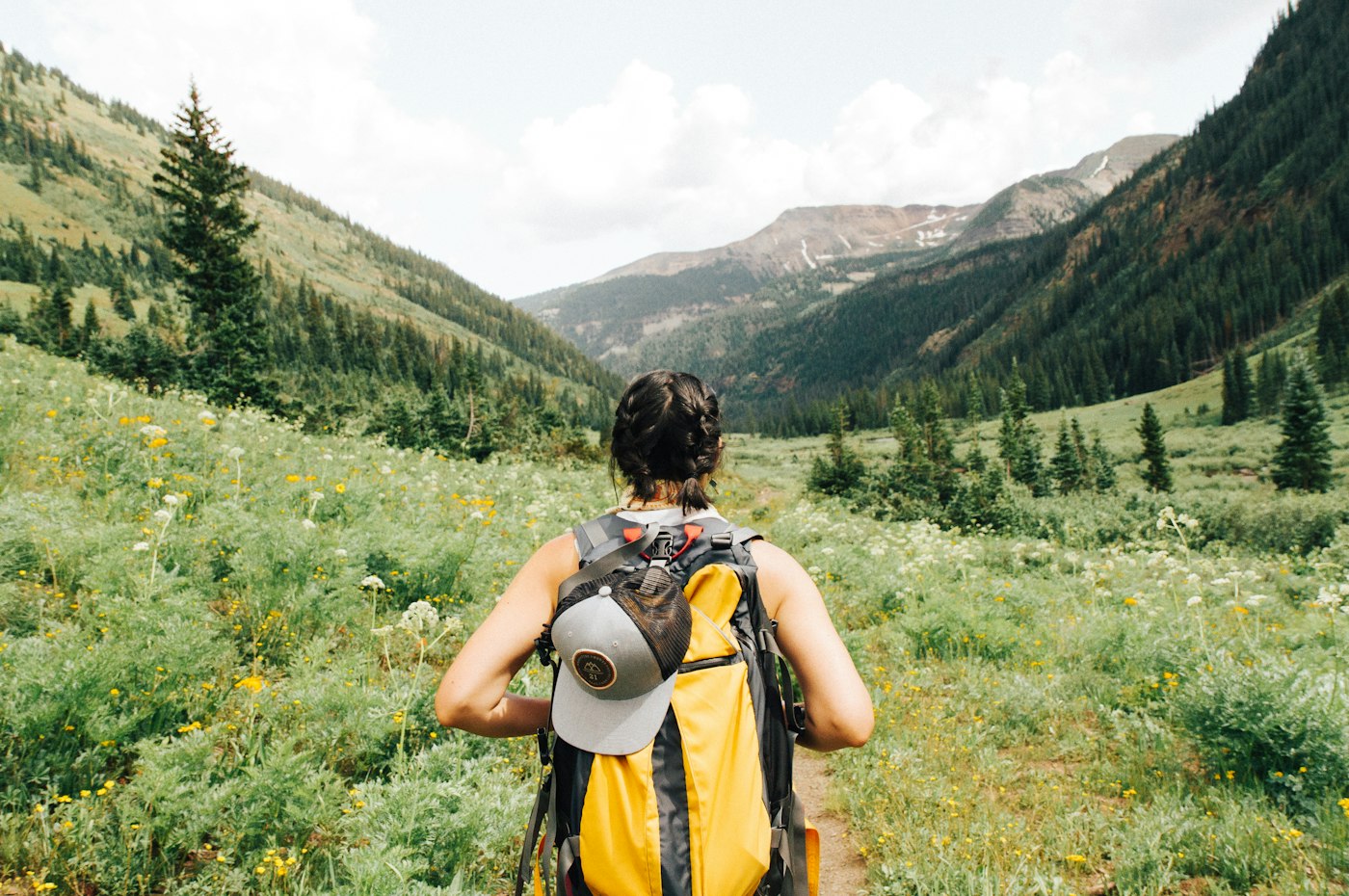 Lone traveler on high mountain trail overlooking ridges